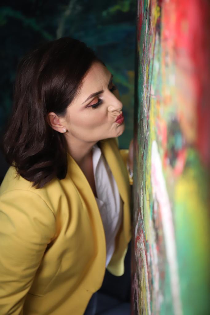 Bild von Sandra neben einem ihrer Kunstwerke